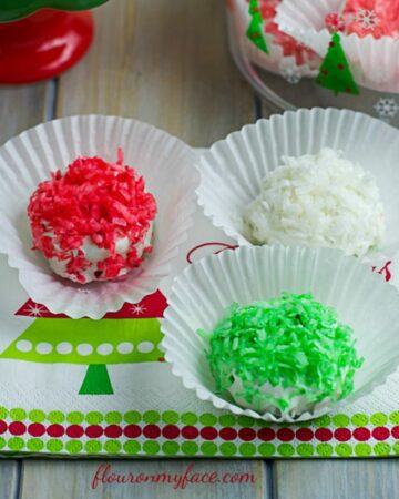 Red, green and white OREO snowball cookies on a holiday napkin.