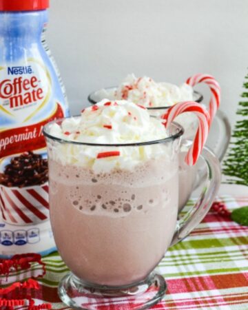 A clear mug filled with peppermint mocha frozen hot chocolate topped with whipped cream.
