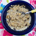 A blue bowl filled with a serving of homemade apple cinnamon raisin oatmeal.