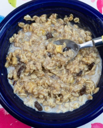 A blue bowl filled with a serving of homemade apple cinnamon raisin oatmeal.