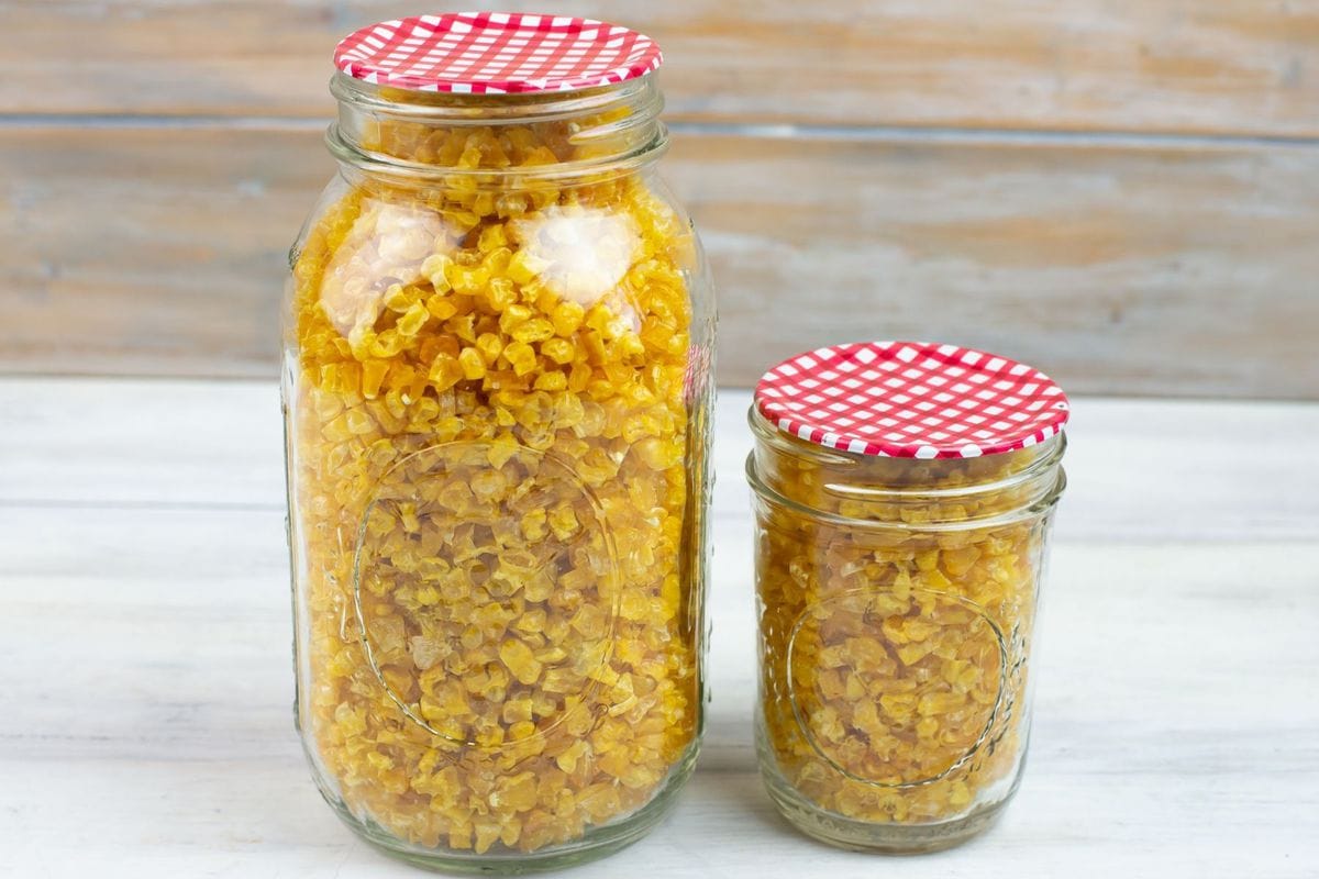 Sealed mason jars filled with corn kernels.