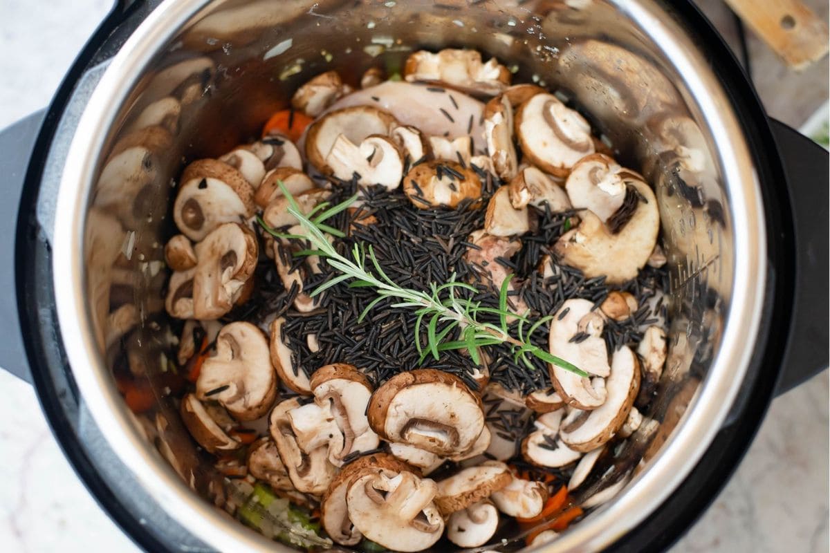 Fresh sliced mushrooms, wild rice and rosemary added to the pot.
