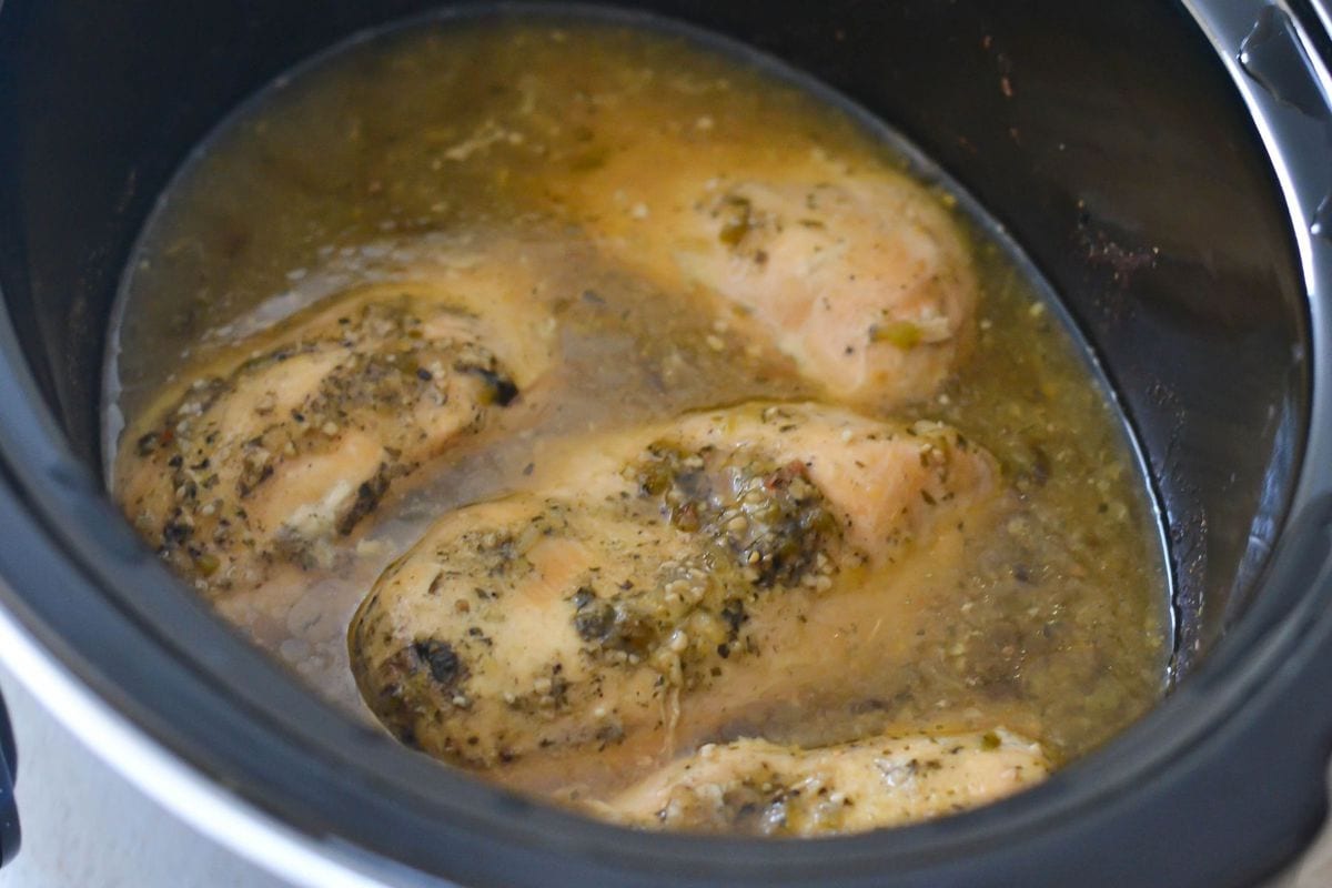 Cooked chicken breasts simmered in Salsa Verde in a slow cooker.