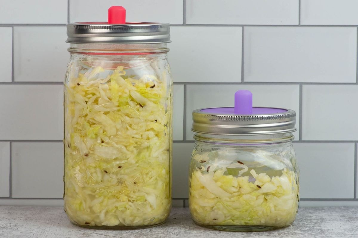 Two glass mason jars filled with homemade German style sauerkraut.