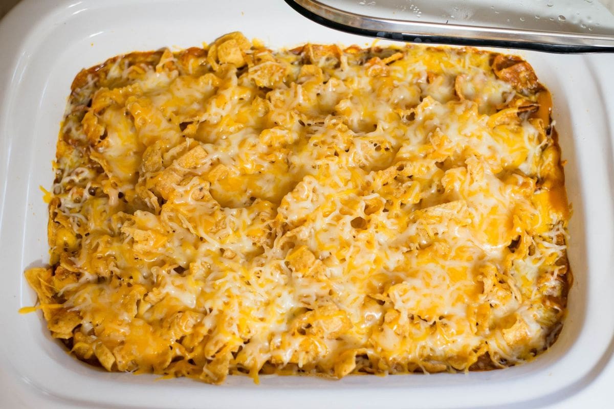 Casserole slow cooker with Frito Taco Casserole topped with melted cheese.