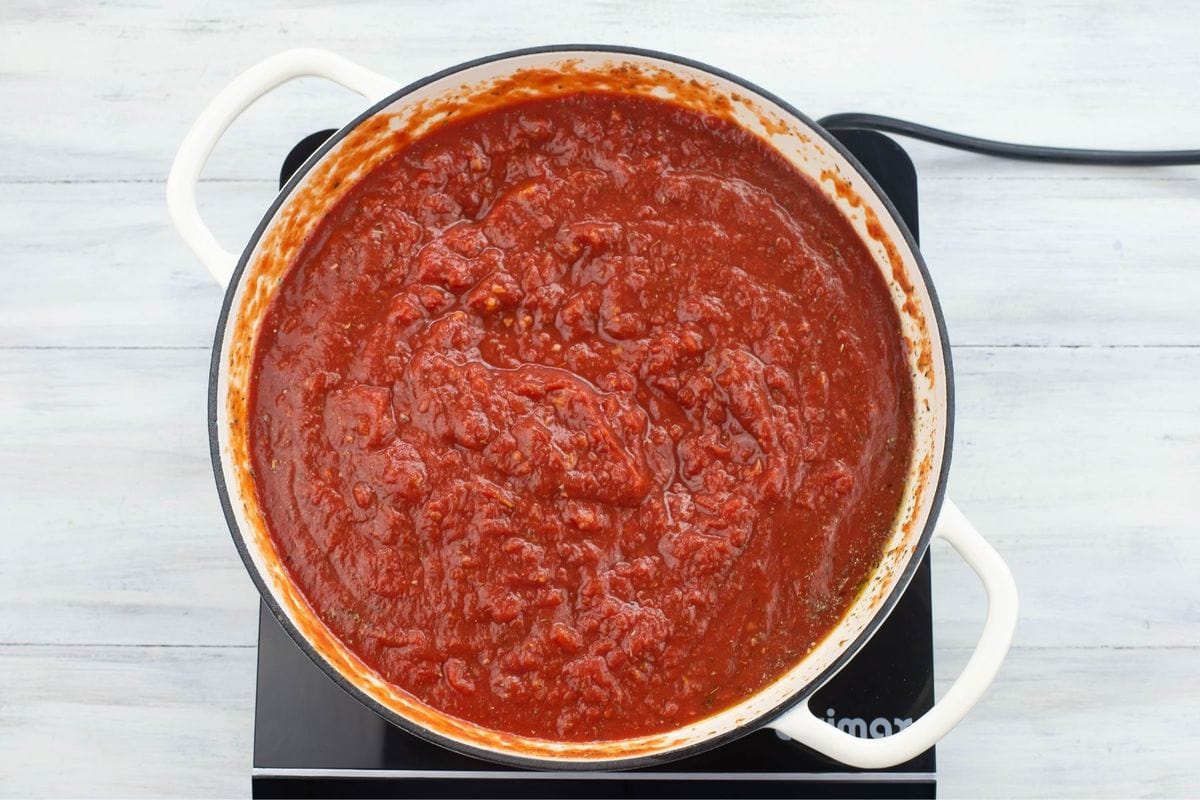 A sauce pan filled with simmered and thickened homemade pizza dough.