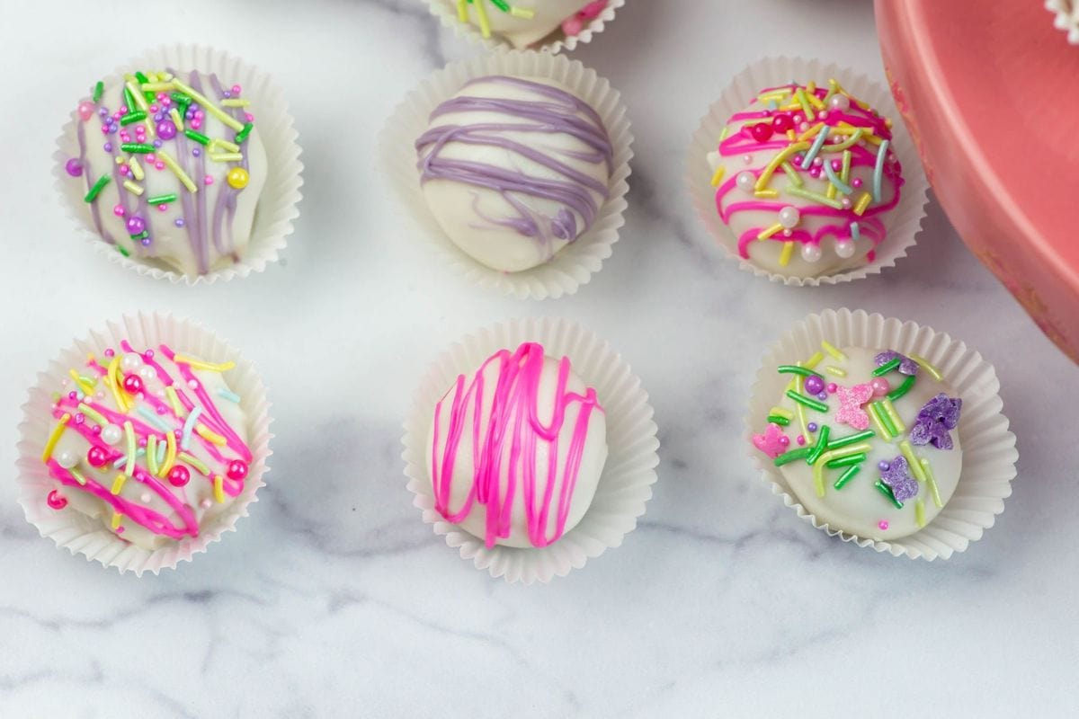 Six Easter cake balls decorated with sprinkles.