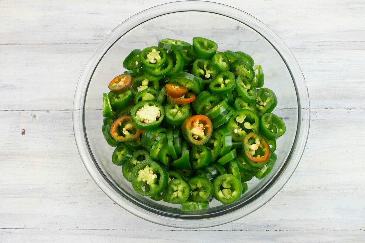 A glass bowl filled with sliced peppers.