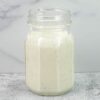 A small jar filled with buttermilk ranch dressing.