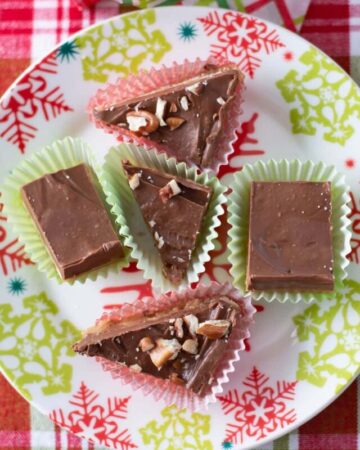 A holiday plate with bite size pieces of homemade Christmas candy in holiday paper cups.
