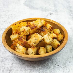 Garlicy homemade croutons in a wooden bowl.