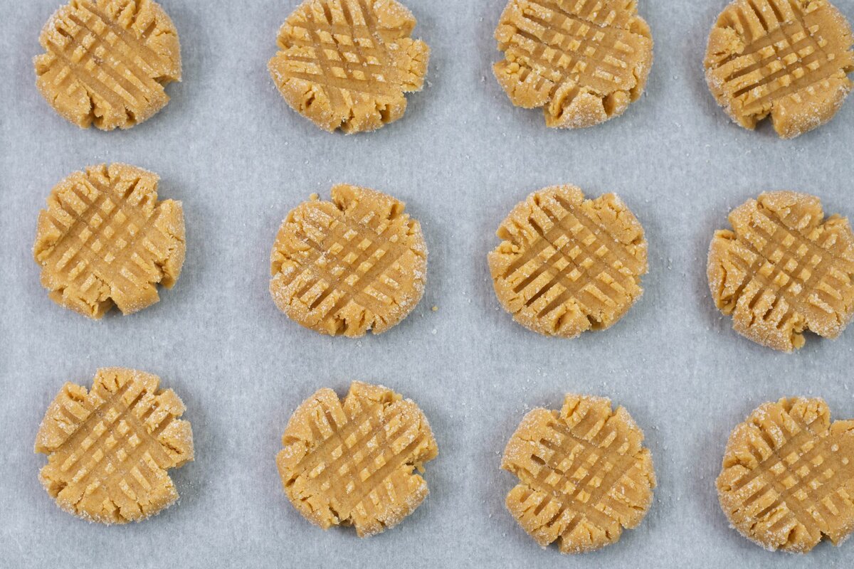 Cris cross markings on unbaked peanut butter cookies.