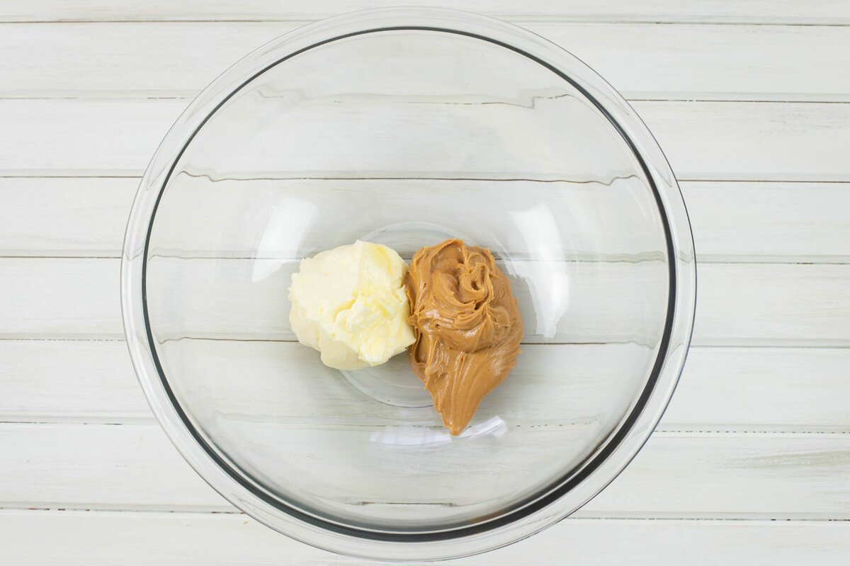 Softened butter and peanut butter in a large glass mixing bowl.