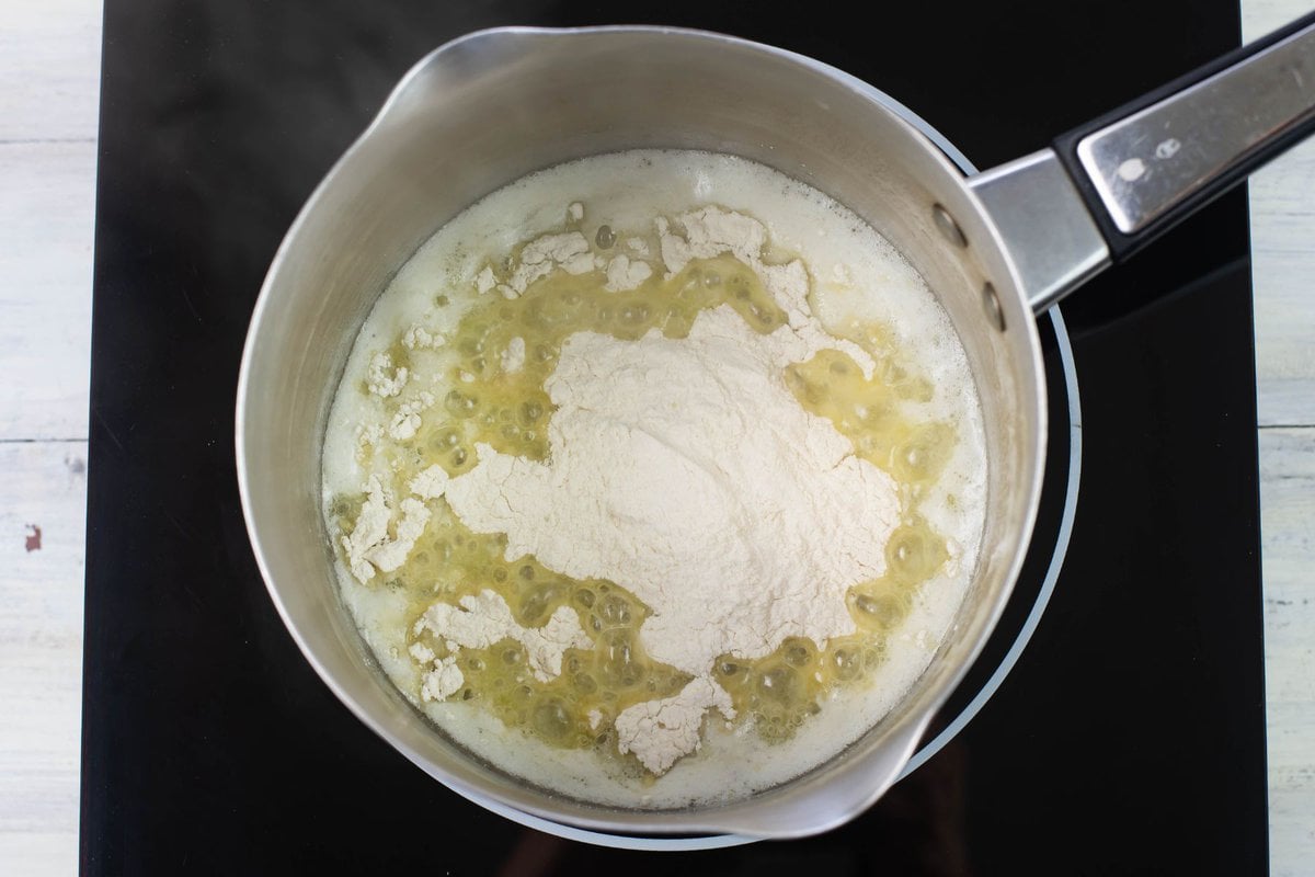 Mixing flour and melted butter in a sauce pan.