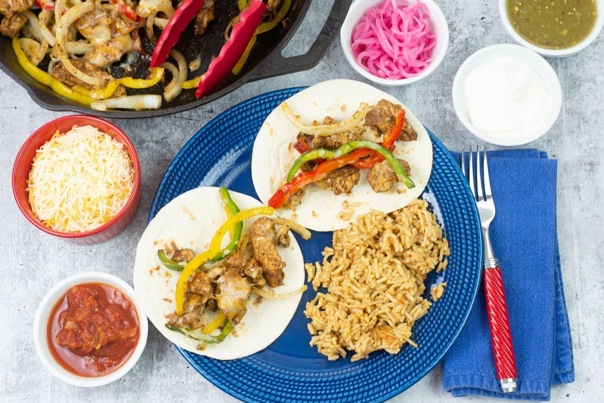 Serving homemade chicken fajitas with toppings.