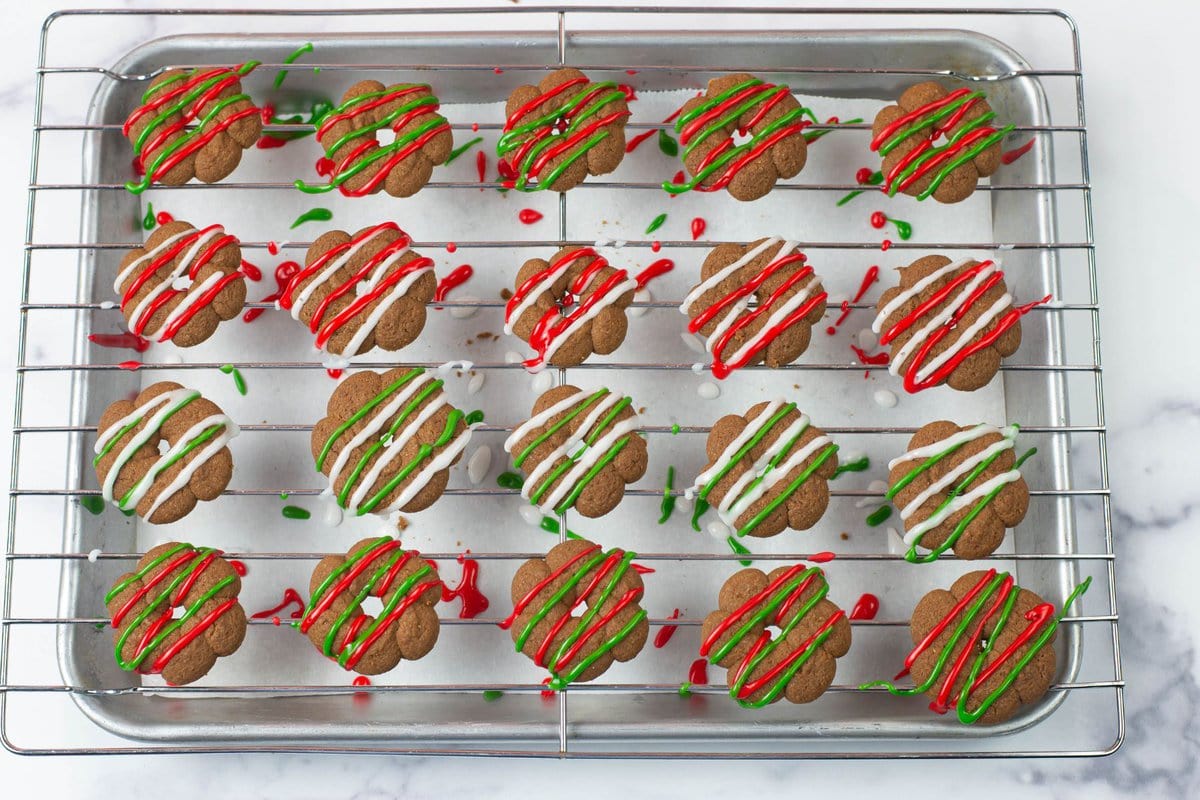 Mocha Spritz cookies decorated with white, red and green sugar drizzle.