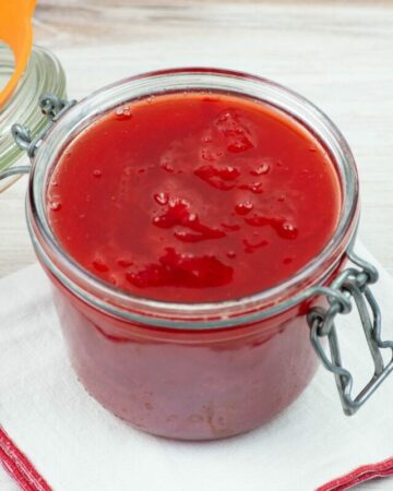 Homemade strawberry sauce in a glass canning jar with a bail type lid.