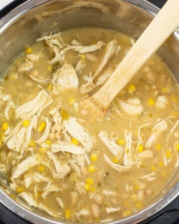 Adding the corn starch slurry to the simmering chili ingredients.