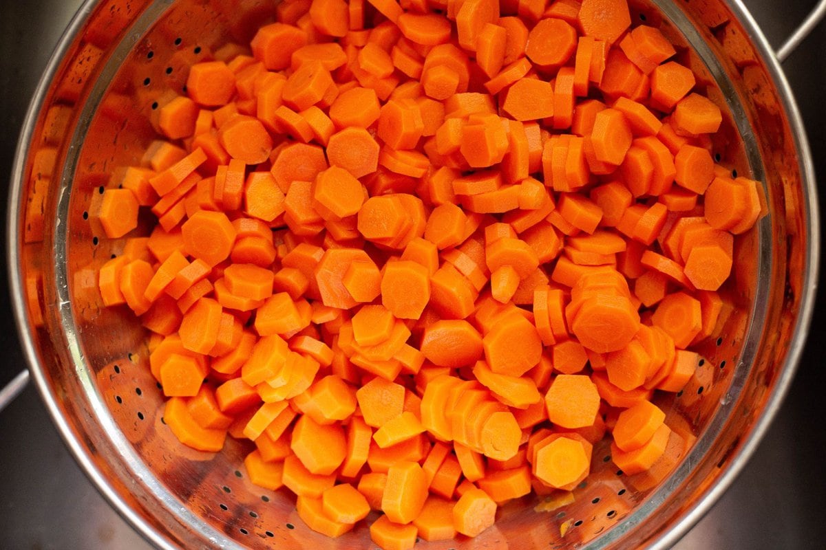 Overhead image showing the blanched carrots draining in a colander.