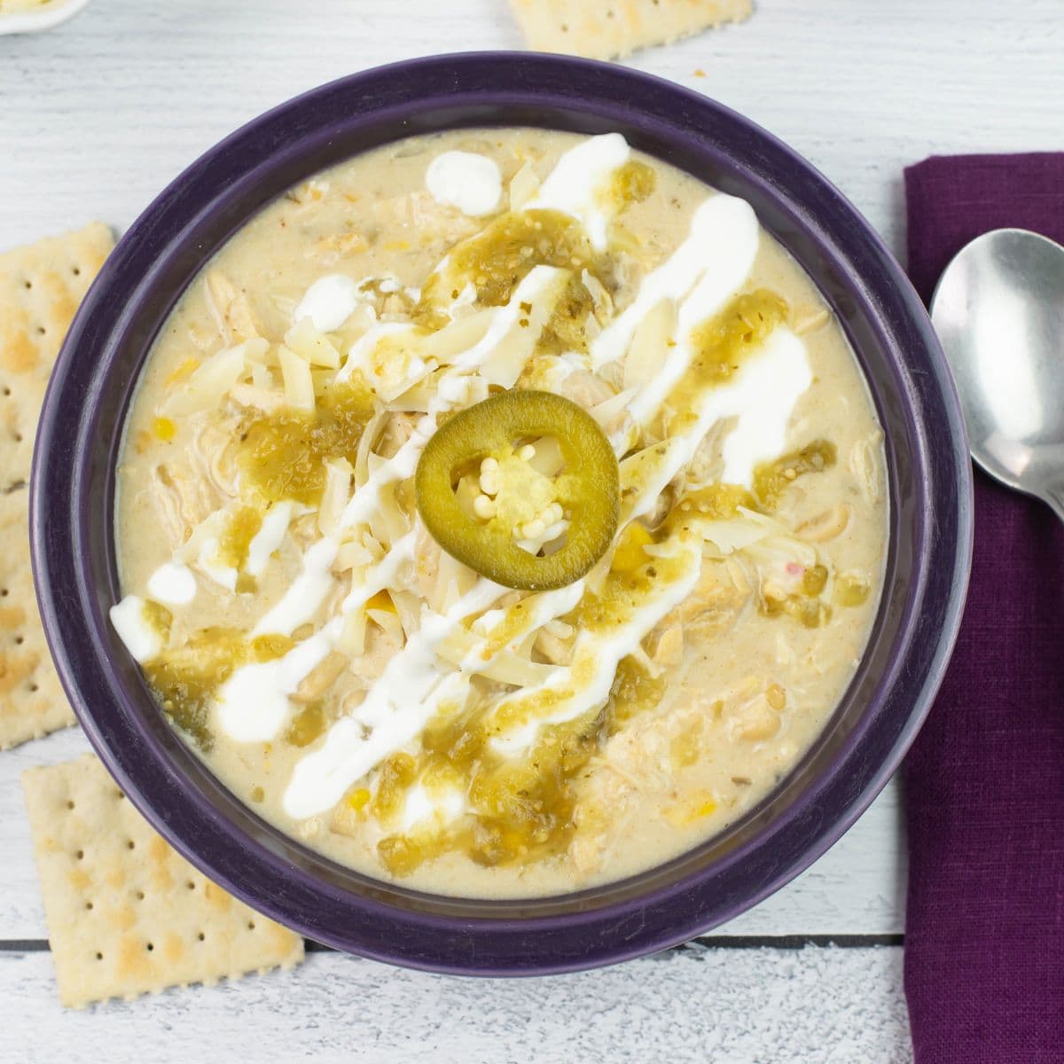 Cheesy chicken chili in a purple bowl.