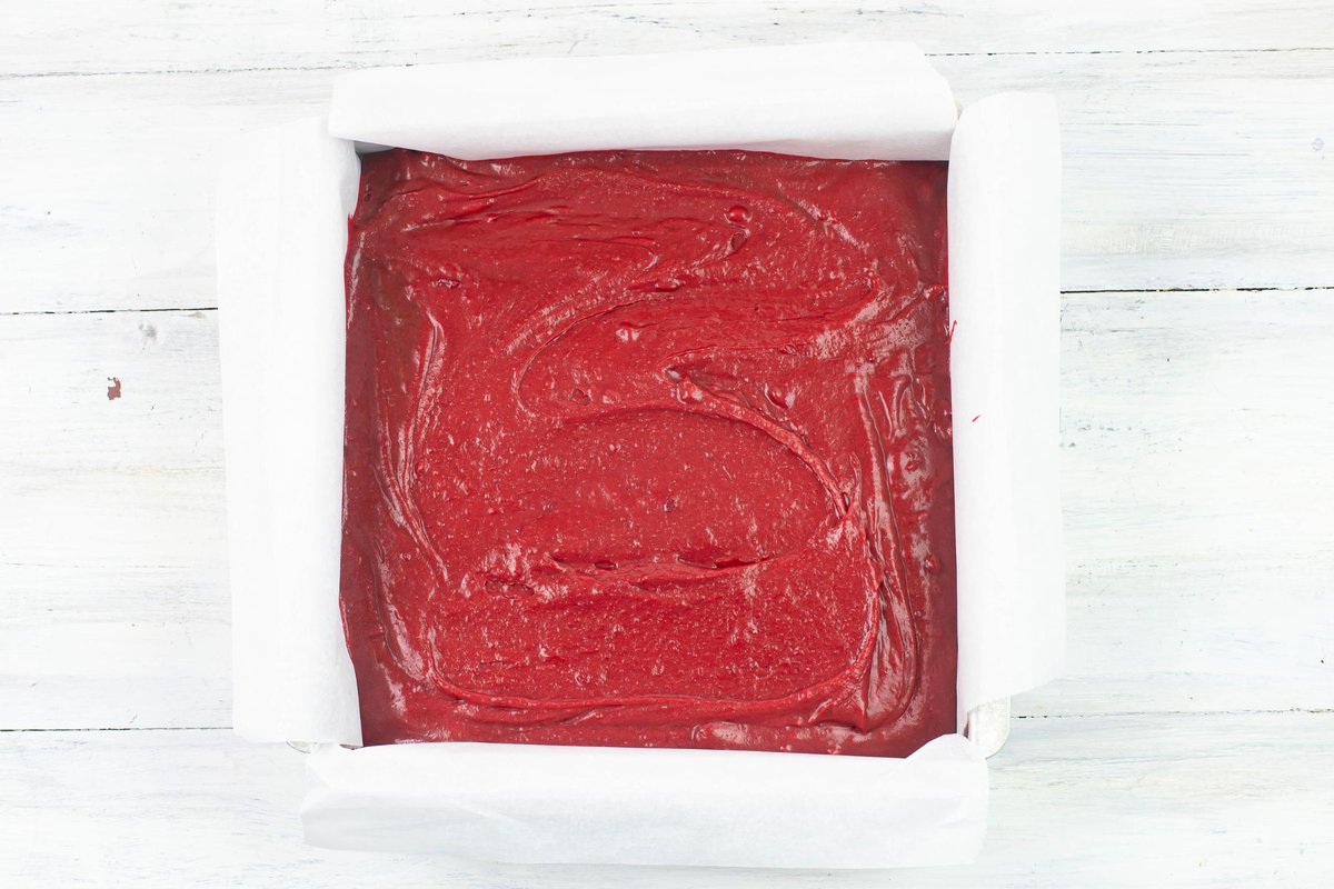 Spreading the red velvet brownie batter into the baking pan.