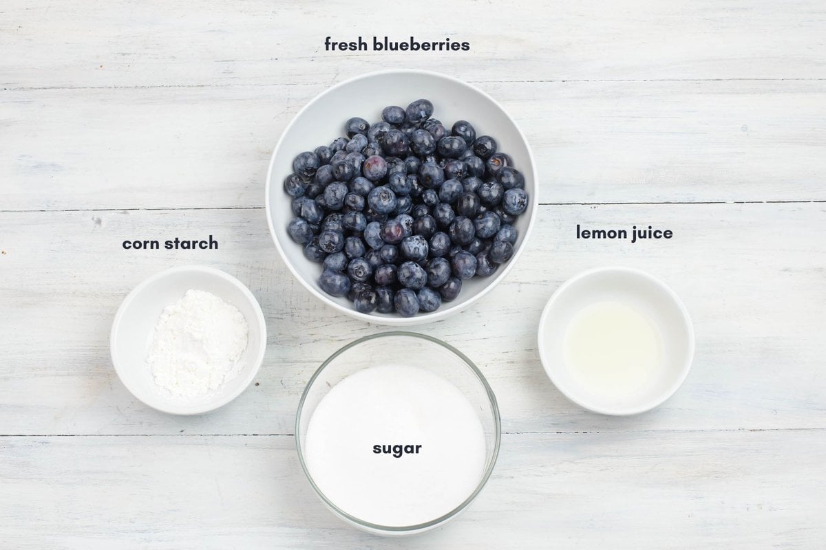 Blueberry sauce ingredients measured out into individual glass bowls.