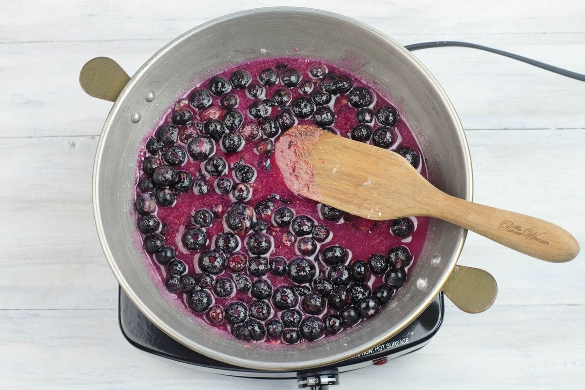 blueberries simmering in a shallow sauce pan.