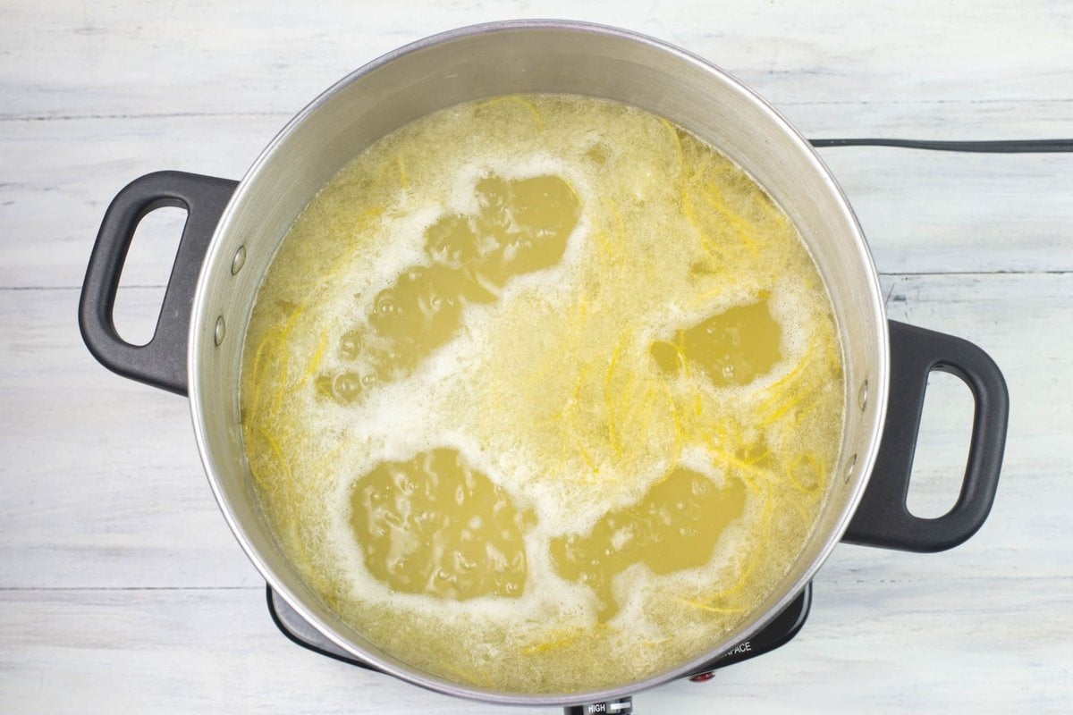 A pot full of lemonade concentrate ingredients at a low boil.