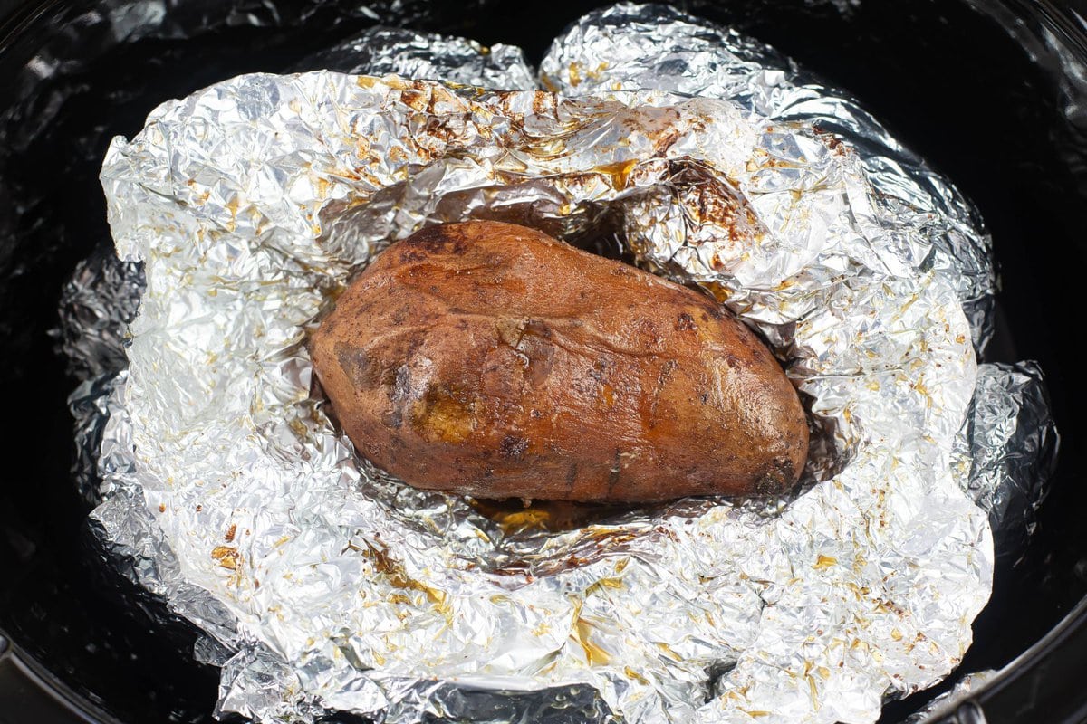 A cooked sweet potato with the foil open and the potato visible.