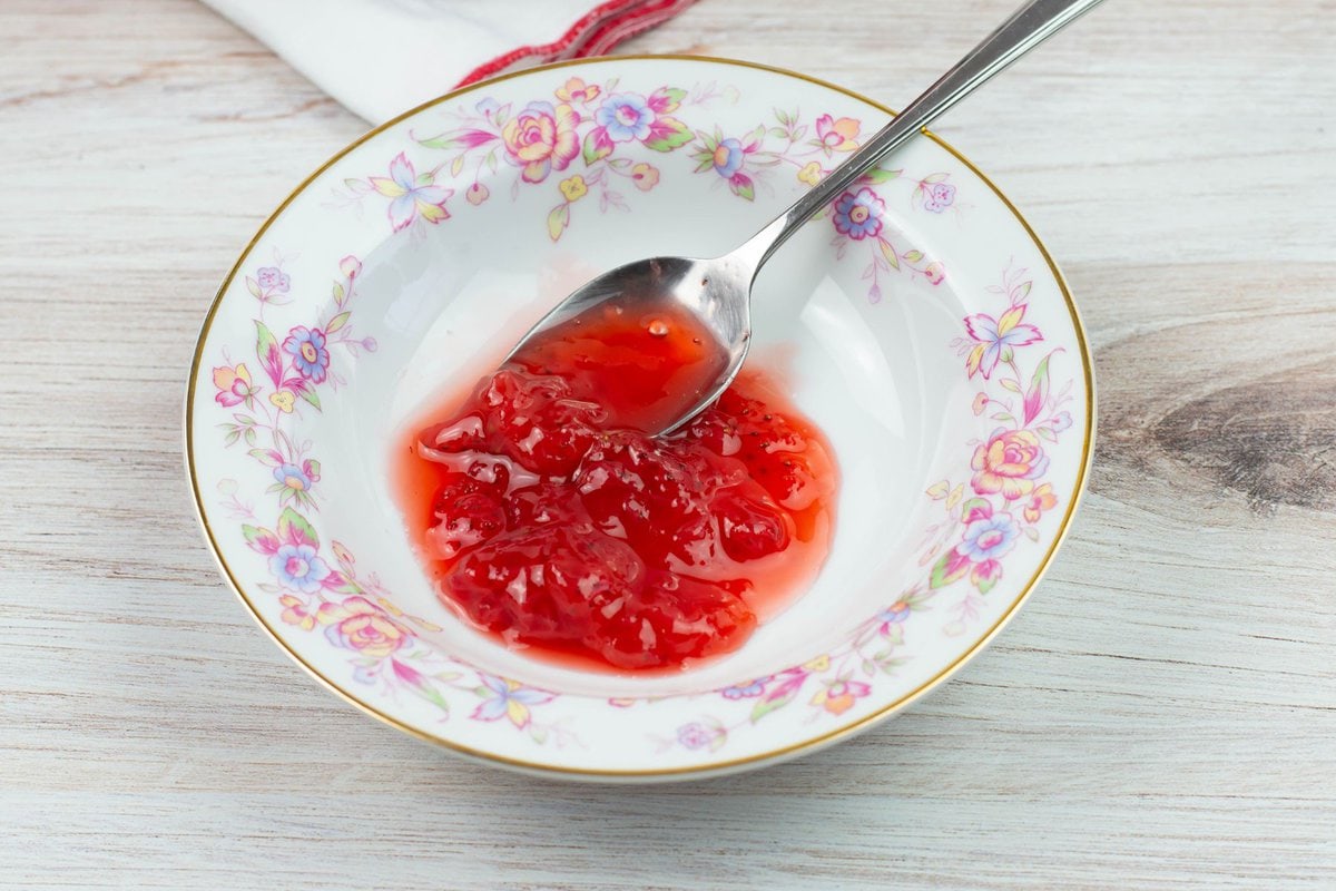 Red berry sauce in a small shallow bowl.