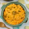 Crock Pot Buffalo Chicken Dip served in a teal clay bowl with chips.