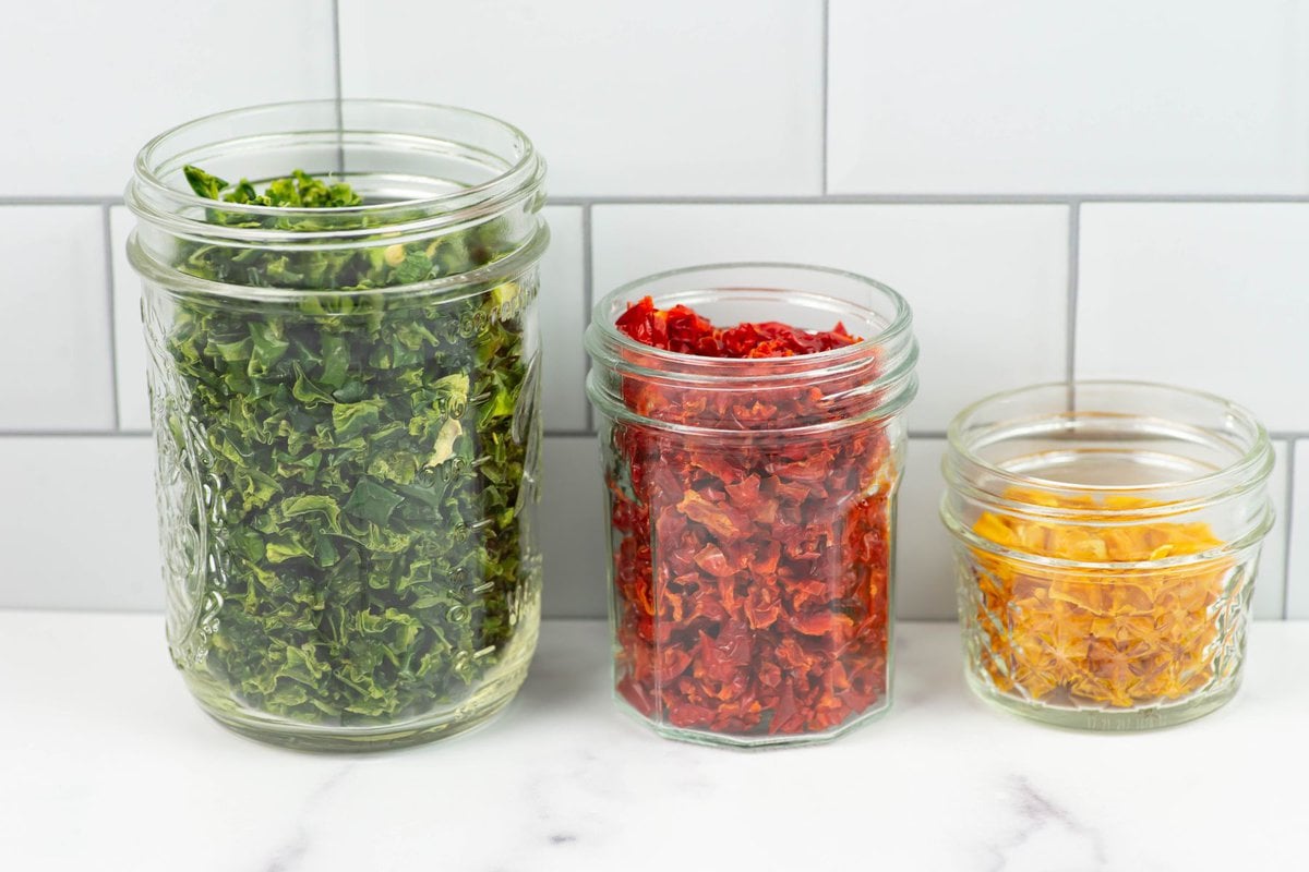 3 glass jars filled with green, red or yellow dried bell peppers.