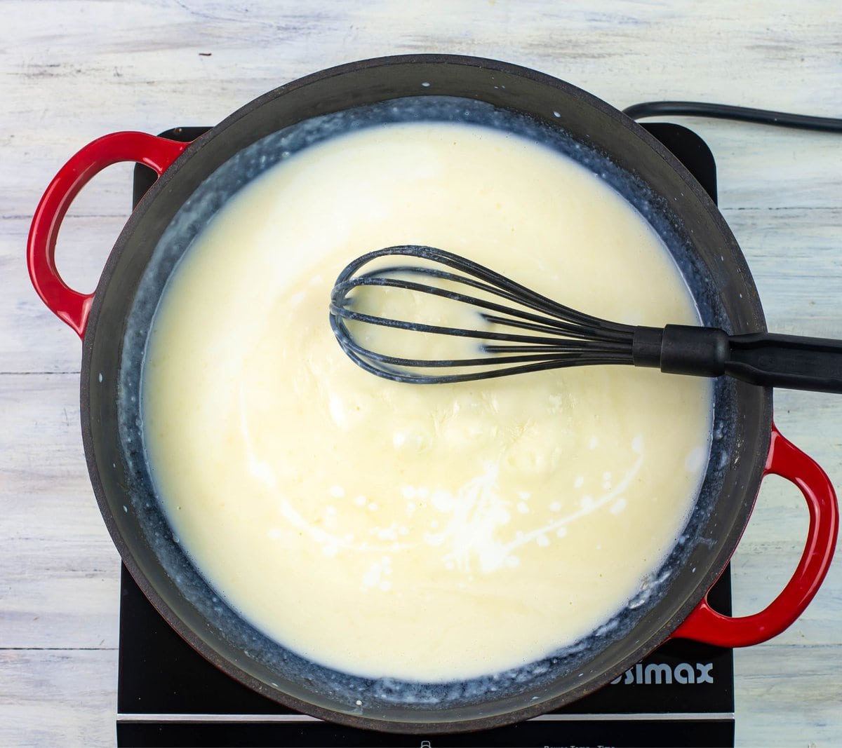 Adding buttermilk to the skillet for alfredo sauce.