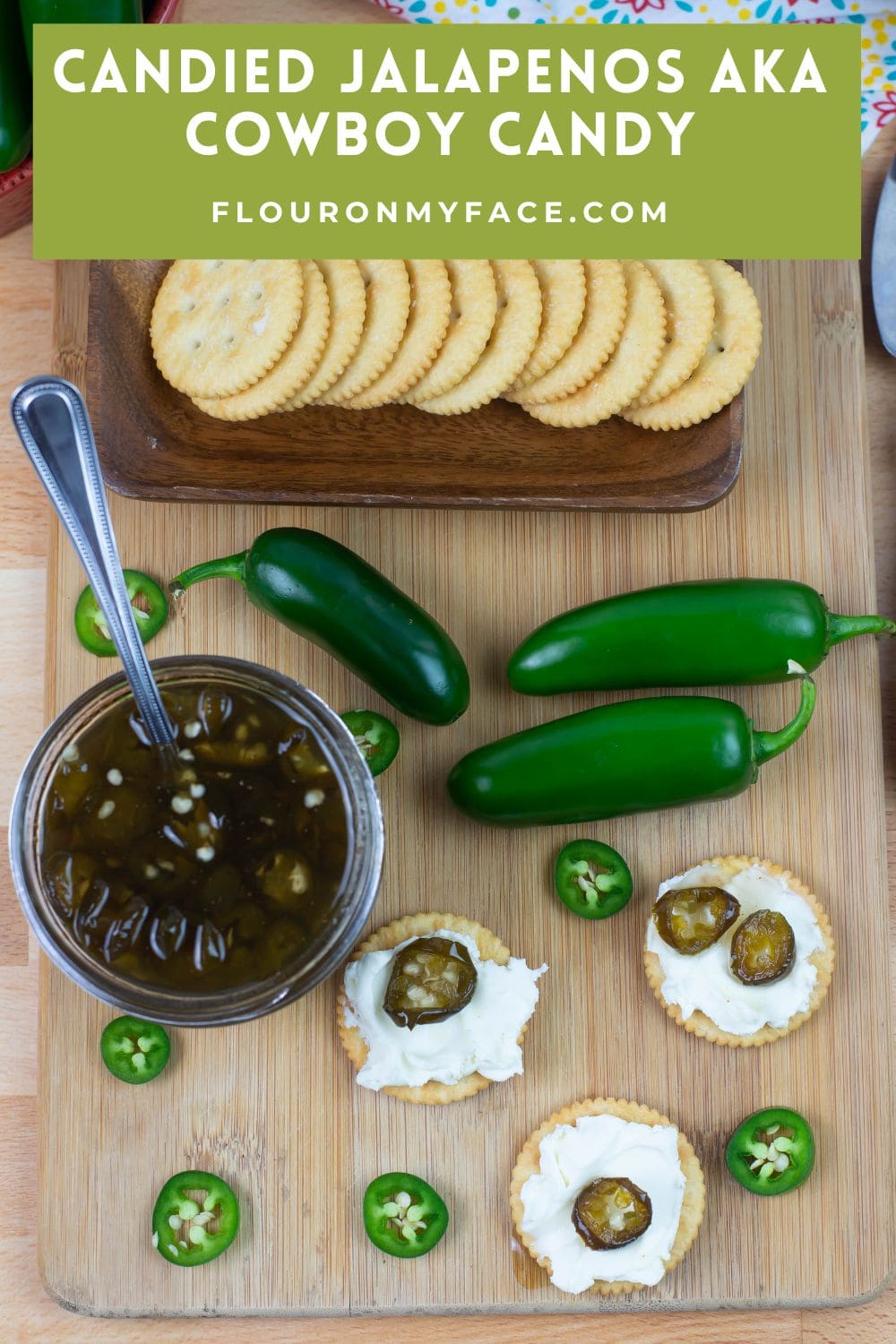 Large vertical image of candied jalapenos served with cream cheese and crackers.