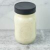 Half pint mason jar filled with cream Garlic Parmesan Dressing.