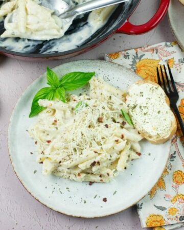 Alfredo sauce with buttermilk served over pasta with sliced and buttered bread.