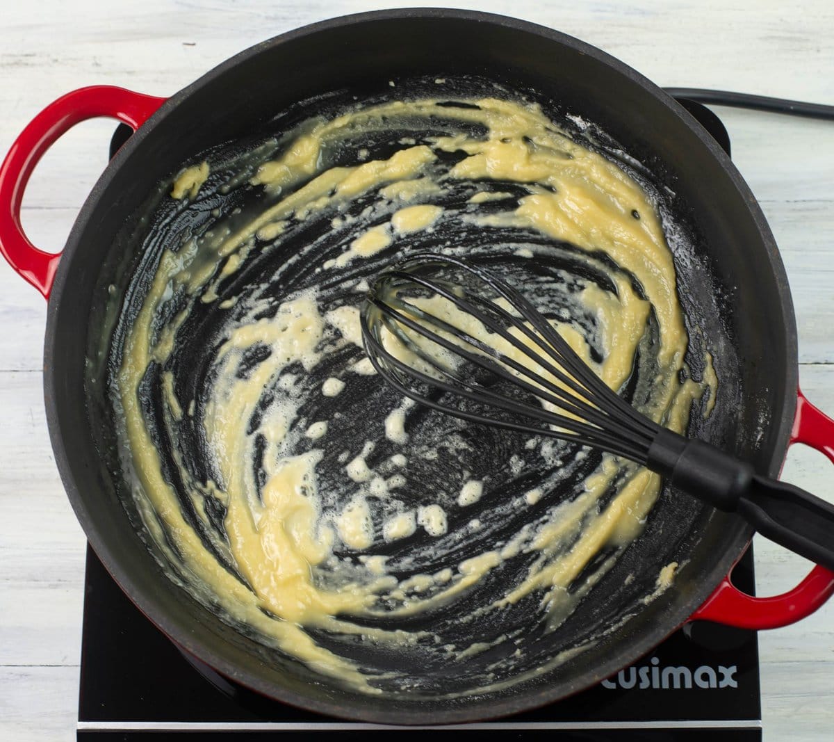 Flour whisked into melted butter into a creamy paste in a skillet.