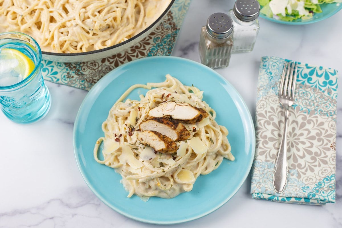 Spicy alfredo sauce with linguine and grilled chicken on a dinner plate.