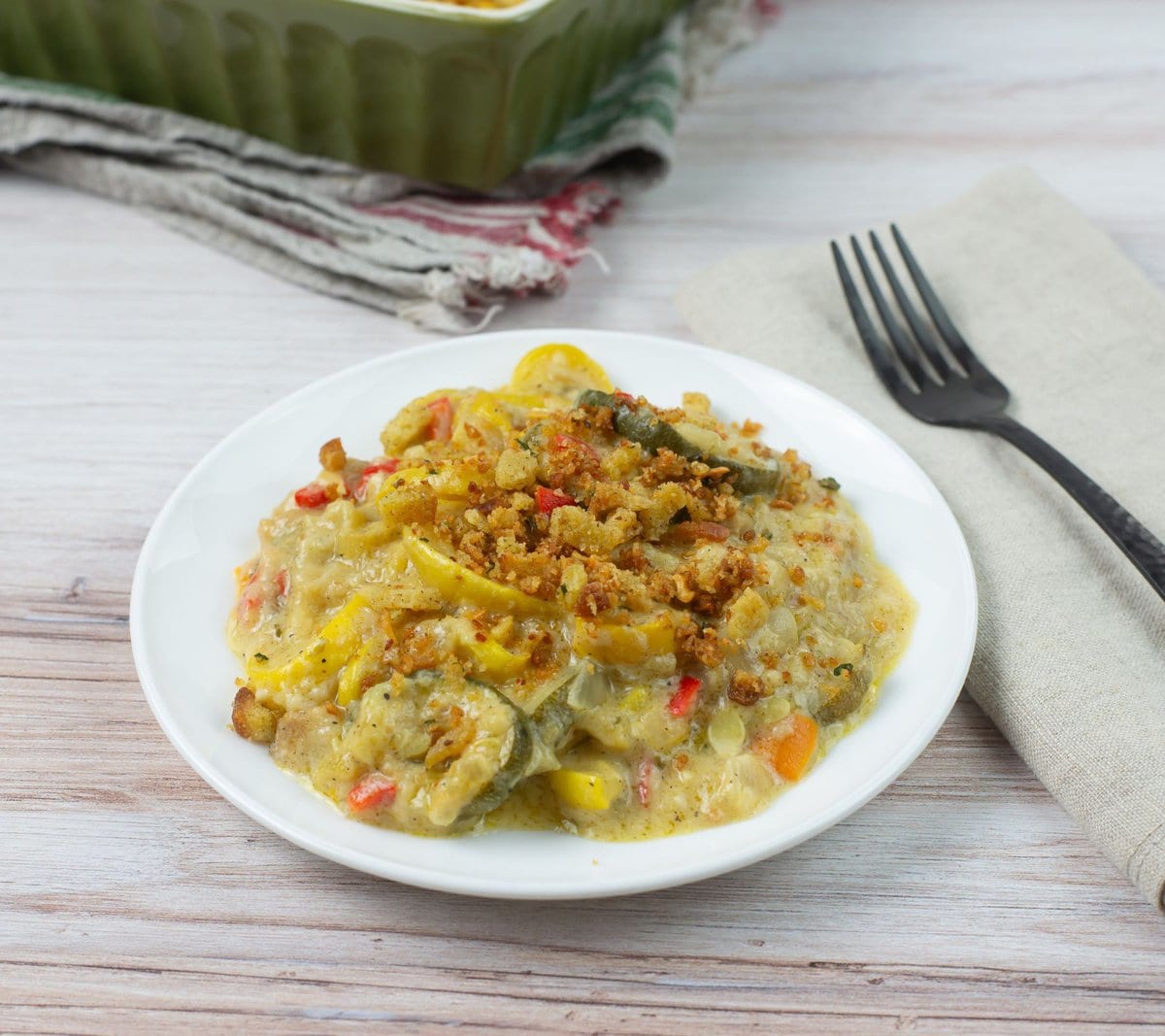 Yellow squash and zucchini casserole with stuffing topping on a white plate..