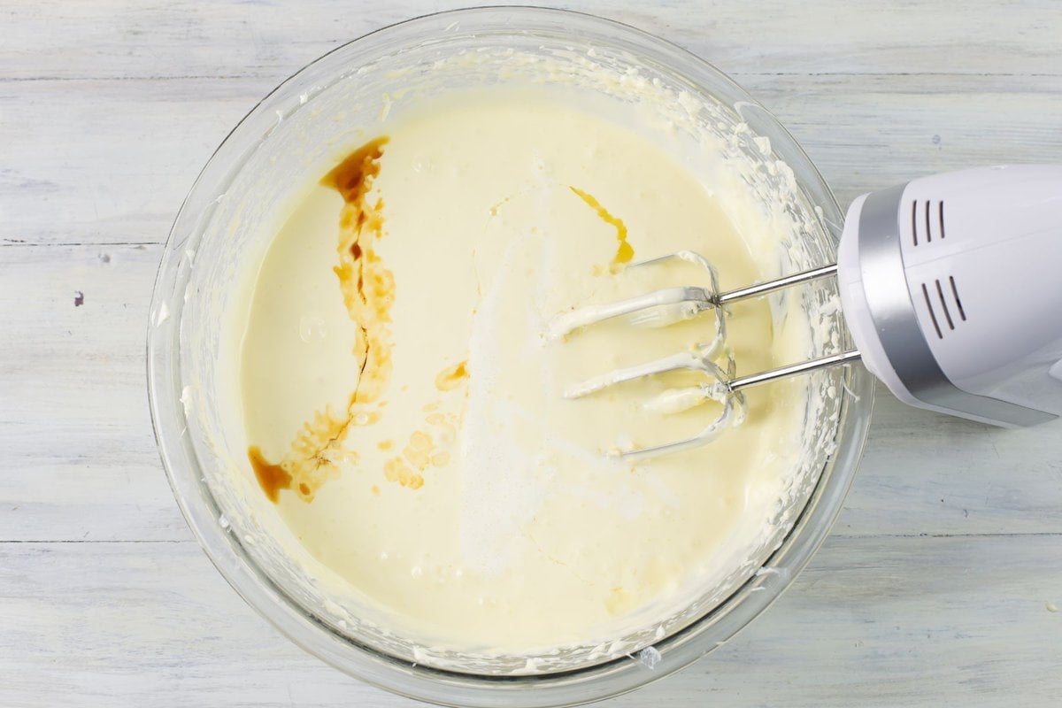 Beating lemon juice, whipping cream and vanilla extract into the cream cheese mixture.