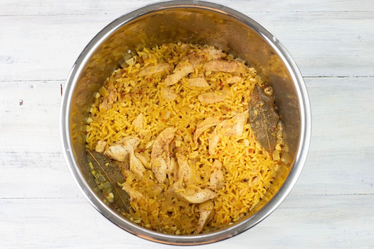 Cooked yellow rice and chicken in the inner pot of the Instant Pot.