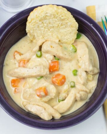 Instant Pot Chicken a la king served over a buttermilk biscuit in a bowl.