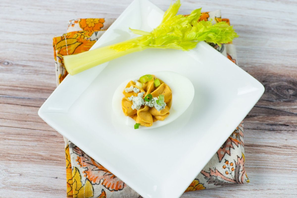 A Buffalo deviled egg on a small appetizer dish.