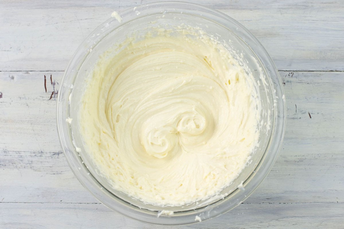 Smooth and creamy cheesecake dip in a glass mixing bowl.