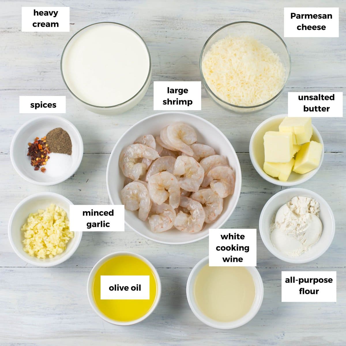 Premeasured shrimp scampi Alfredo ingredients in individual bowls.