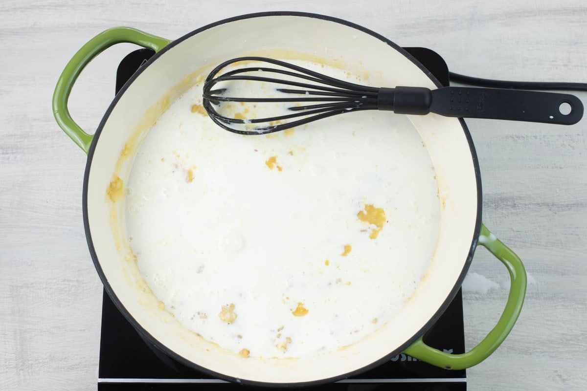 Adding ½ the cream to the skillet with the butter roux.
