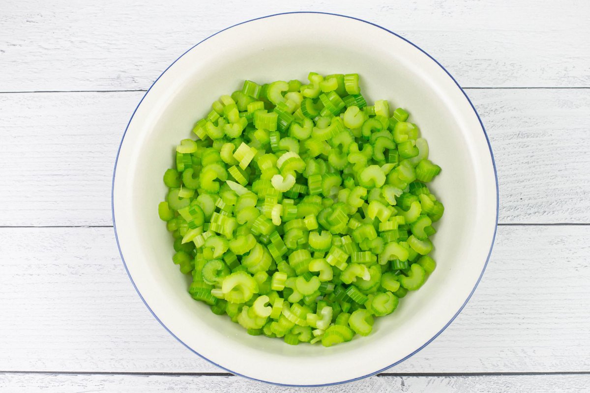 Thinly slice celery in a large enamel bowl.