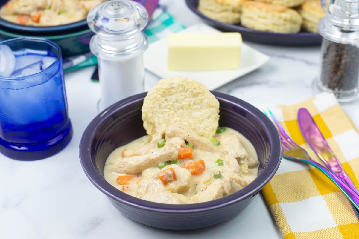Homemade chicken a la king served over a buttermilk biscuit in a bowl.