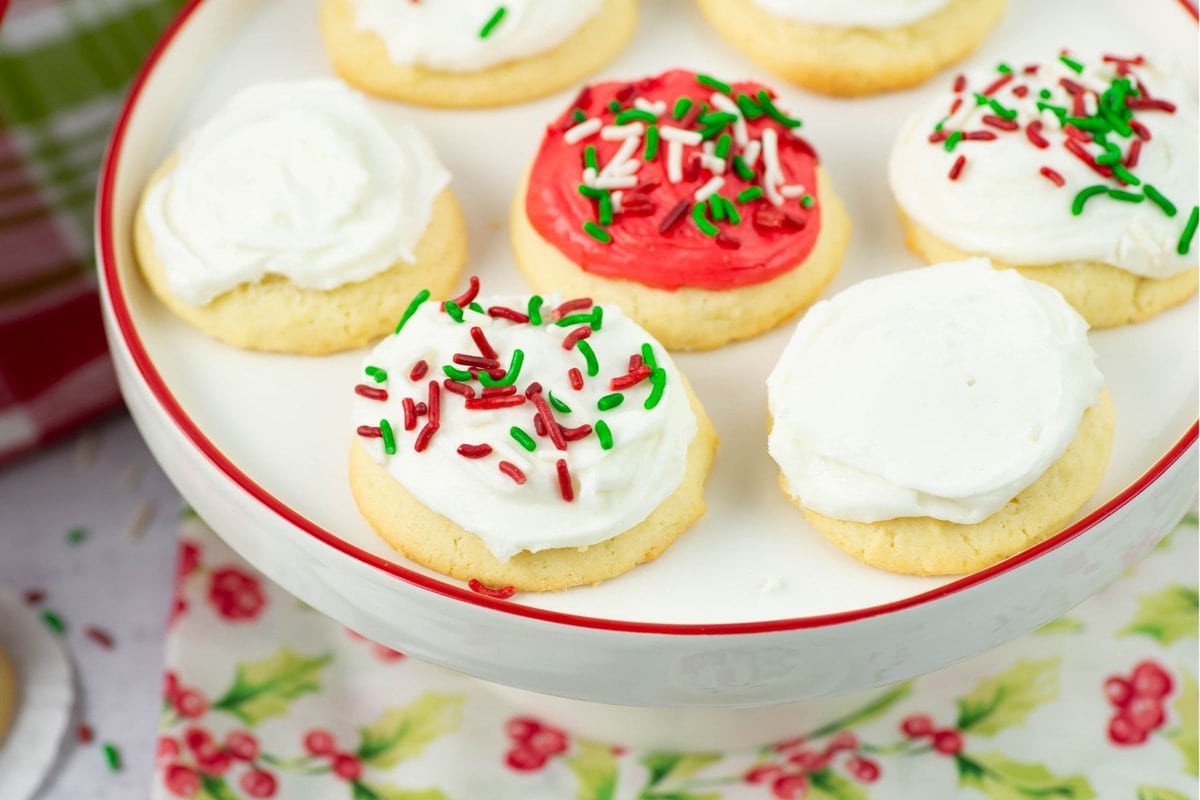 White and red frosted cookies on a cake stand.