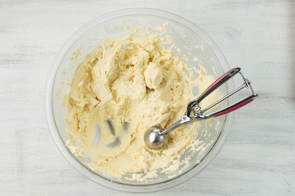 A cookie dough scoop in the bowl of cookie dough batter.